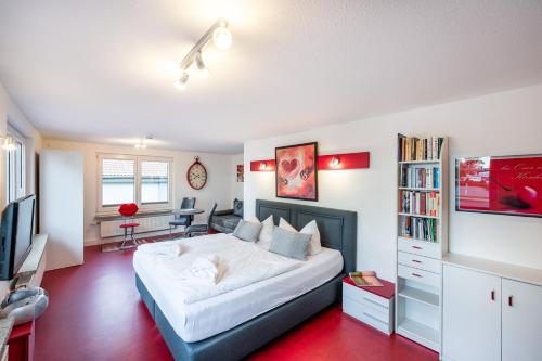 a bedroom with a large white bed and a desk at Oma's Küche & Quartier in Binz