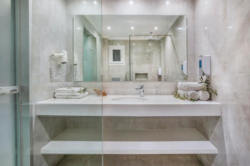 a bathroom with a sink and a mirror at Anna Hotel in Pefkohori