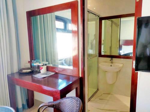 a bathroom with a sink and a toilet and a mirror at El Nido Beach Hotel in El Nido