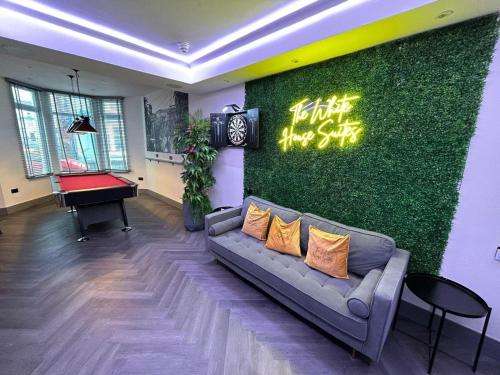 a living room with a couch and a green wall at The White House New York Suites in Blackpool