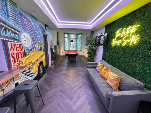 a room with a couch and a table with a car on the wall at The White House New York Suites in Blackpool