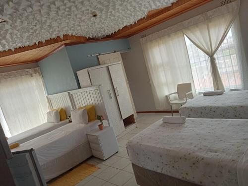 sypialnia z 2 łóżkami i 2 oknami w obiekcie BARAKA mtata ! w mieście Mthatha