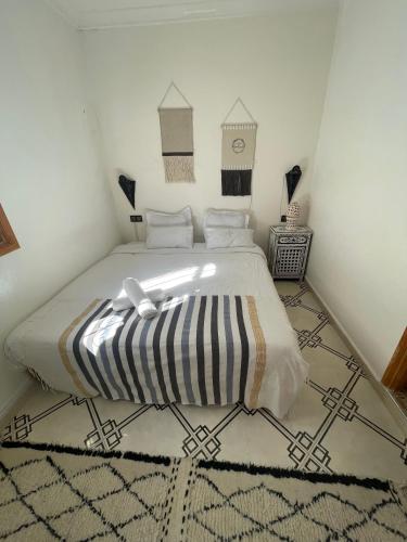 a bedroom with a bed with a black and white blanket at Dar El Hayet in Tangier