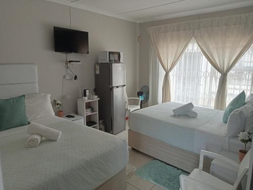 1 dormitorio con 2 camas y nevera en BARAKA mtata ! en Mthatha