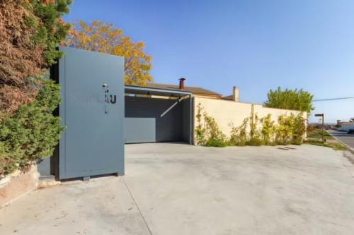 a garage with a white door in a driveway at Masia Cal Sisplau, con piscina y rodeada de viñedos a 10 minutos de Vilafranca del Penedés, Barcelona ,Cataluña in San Martín Sarroca
