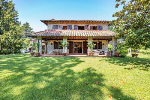 una casa con un gran patio delante de ella en Villa ai Boschetti, en Luciano