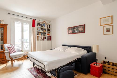 une chambre avec un lit et une chaise dans l'établissement Veeve - Swan's Nest, à Paris