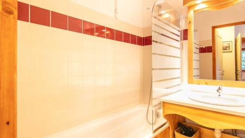 une salle de bain avec un lavabo, une baignoire et un miroir dans l'établissement V du Bachat Joubarbe 1 6 pers, à Chamrousse