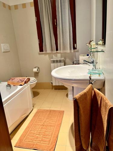 a bathroom with a sink and a tub and a toilet at Casa Corinaldesi in Marotta