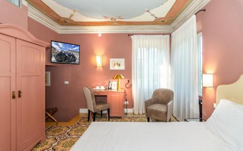 a hotel room with a bed and a desk at Hotel Albergo Villa Marta in Lucca