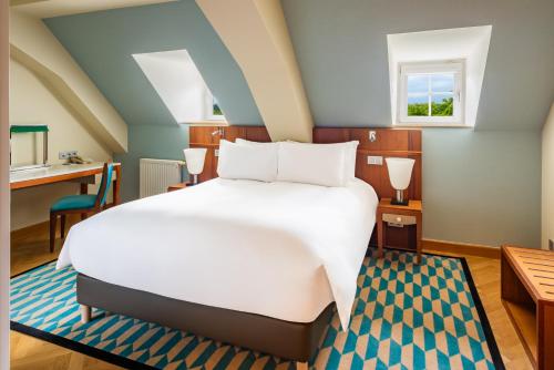 a bedroom with a large white bed and a desk at Sofitel Grand Sopot in Sopot