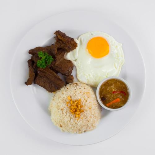 a plate of food with a fried egg and rice at AMALFI718 HOTEL in Lipa
