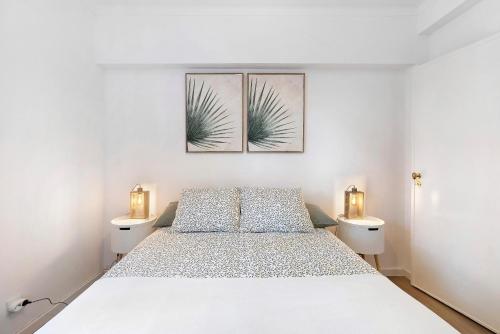 a bedroom with a bed and two lights on the wall at Jardim da Parada in Cascais