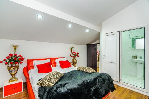 a bedroom with a large bed with red pillows at Sera Boutique Hotel in Baku