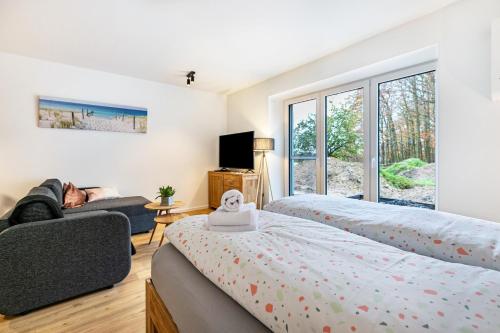 1 dormitorio con 2 camas y sofá en Voldewraa Wohnung 5 en Husby