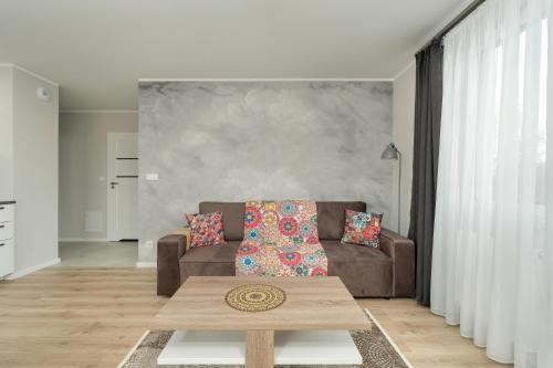 Apartment with 2 Bedrooms and FREE GARAGE Poznań by Renters في بوزنان: غرفة معيشة مع أريكة وطاولة قهوة