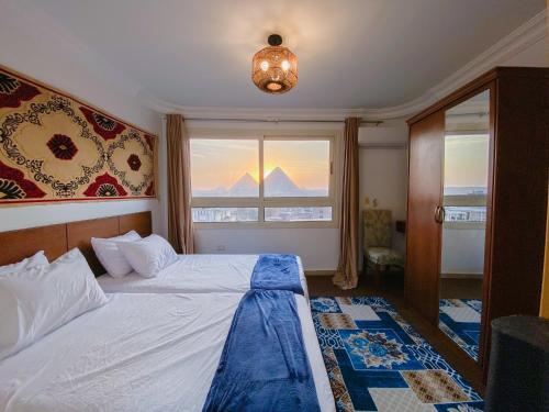 a bedroom with a bed and a window at Oscar pyramids view in Cairo