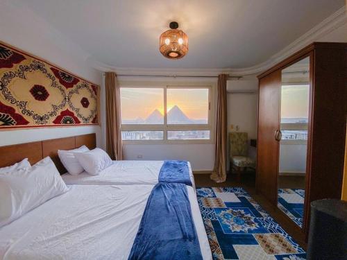 a bedroom with a bed and a window with a view at Oscar pyramids view in Cairo