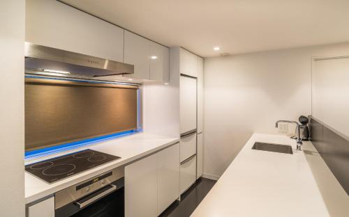 a kitchen with white cabinets and a stove at The Setsumon in Kutchan
