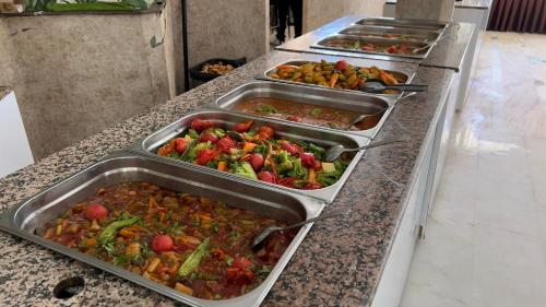 una fila di vassoi di verdure su un bancone di KLEOPATRA SUNLIGHT HOTEL a Alanya