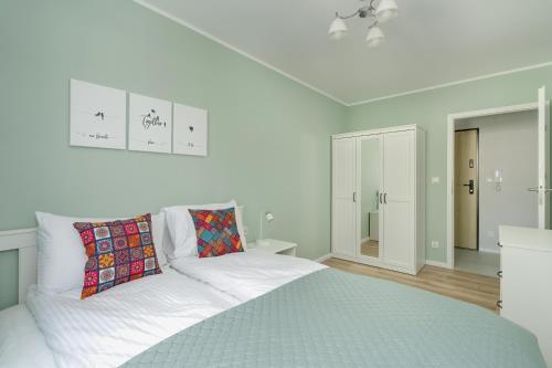 Apartment with 2 Bedrooms and FREE GARAGE Poznań by Renters في بوزنان: غرفة نوم بيضاء مع سرير وبطانية زرقاء