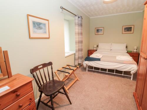 a bedroom with a bed and a chair in it at Golden Fleece Cottage in Berwick-Upon-Tweed