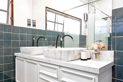 a bathroom with two sinks and a mirror at Sathorn Private Pool Villa in Bangkok