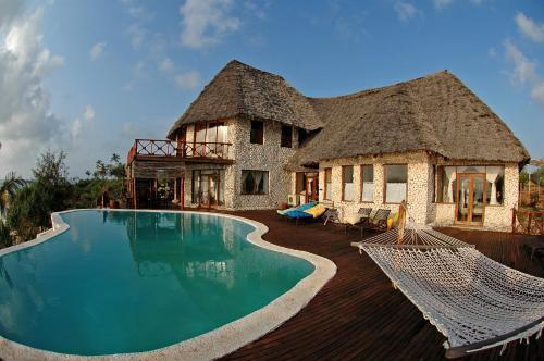 a house with a swimming pool in front of a house at Zi Villa Main House in Matemwe
