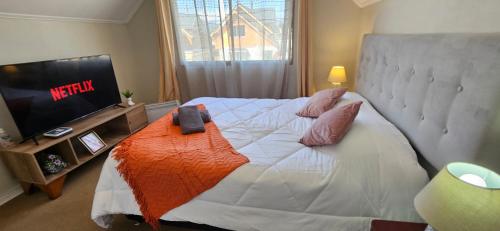 - une chambre avec un grand lit et une télévision dans l'établissement Machali Habitación Matrimonial con AIRE ACONDICIONADO Estacionamiento Privado, à Machalí