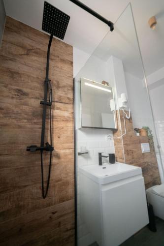 a bathroom with a sink and a shower with a mirror at Kuca 59 in Jahorina