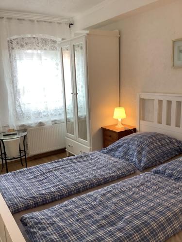 a bedroom with two beds and a lamp and a window at Zimmer Wolkenlos in Dahme