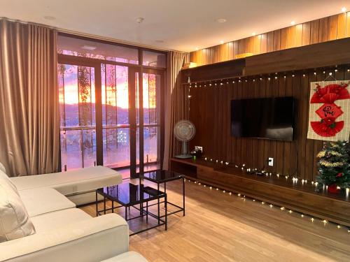 a living room with a white couch and a tv at Ho Cozy Đà Lạt Center in Da Lat