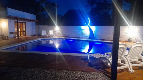 a swimming pool at night with chairs around it at Posada Yaguane in La Paloma