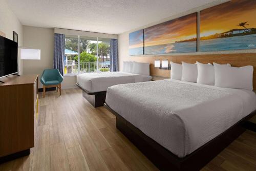 Кровать или кровати в номере Days Inn & Suites by Wyndham Fort Pierce Midtown