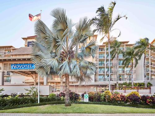 una palmera frente a un hotel en Novotel Cairns Oasis Resort en Cairns