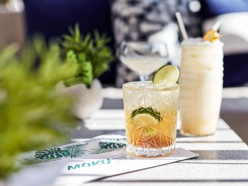 a table with two drinks on a table at Novotel Cairns Oasis Resort in Cairns