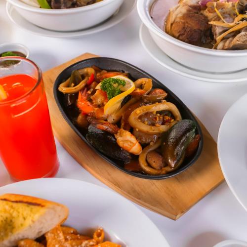 a plate of food on a table with a plate of food at AMALFI718 HOTEL in Lipa