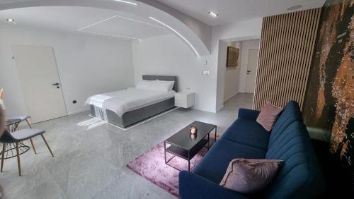 salon z niebieską kanapą i łóżkiem w obiekcie Hagenauer House w Wiedniu