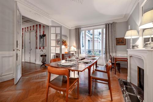 une salle à manger avec une table et des chaises dans l'établissement Veeve - Epic Romance, à Neuilly-sur-Seine