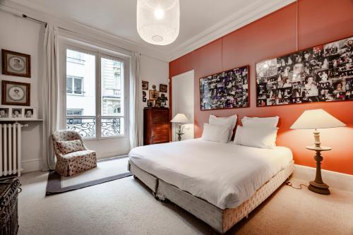 ein Schlafzimmer mit einem großen Bett und einem Stuhl in der Unterkunft Veeve - Epic Romance in Neuilly-sur-Seine