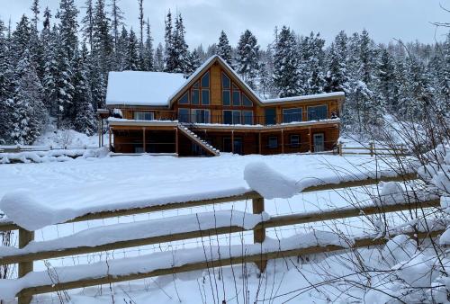 a log cabin in the snow with trees at Ponderosa Glen @ Ashley Lake in Kila
