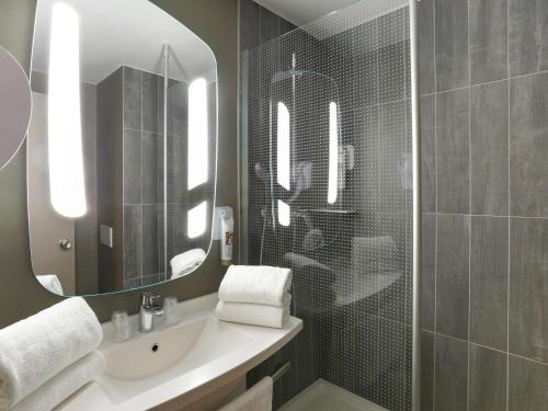 uma casa de banho com um lavatório e um espelho em ibis Genève Centre Gare em Genebra