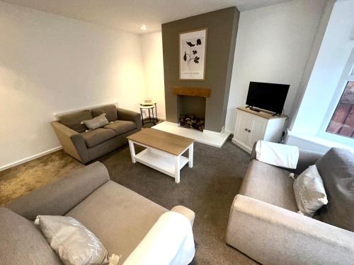a living room with two couches and a television at Seaton House by Blue Skies Stays in Seaton Carew