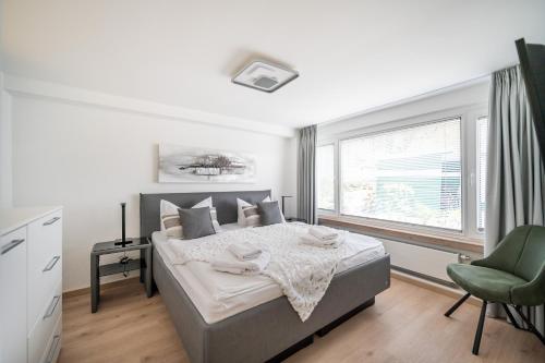 a bedroom with a bed and a chair and a window at Oma's Küche & Quartier in Binz