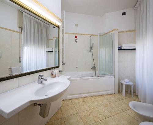 uma casa de banho com um lavatório, uma banheira e um chuveiro em Best Western Hotel Major em Milão