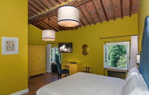 a bedroom with a white bed and a yellow wall at Hotel Albergo Villa Marta in Lucca
