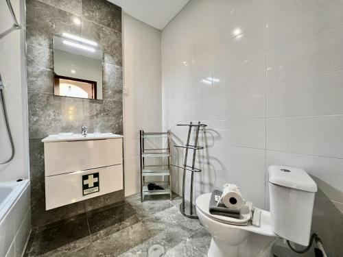 een badkamer met een toilet, een wastafel en een spiegel bij Albufeira Central 7 by Homing in Albufeira