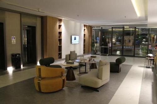 a lobby with chairs and tables in a building at Al Muhaidb Residence Jawazat in Riyadh