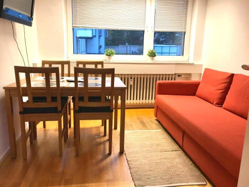- un salon avec une table et un canapé dans l'établissement Relax Aachener Boardinghouse Budget, à Aix-la-Chapelle