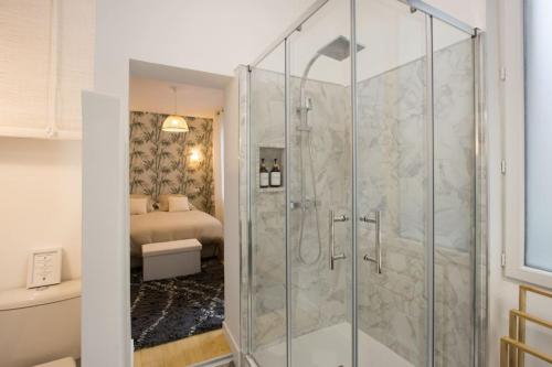 W łazience znajduje się prysznic ze szklanymi drzwiami. w obiekcie Central St Aubin dans un écrin de verdure w Tuluzie